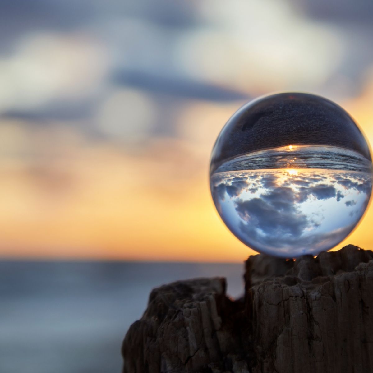 Abendhimmel leicht verschwommen, im Vordergrund eine Glaskugel durch die der Abendhimmel zu sehen ist